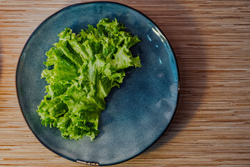 a piece of lettuce on the table on a porcelain plate