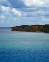 Ein Küstenabschnitt der Normandie mit klarem blauen Wasser. Wolkiges Wetter