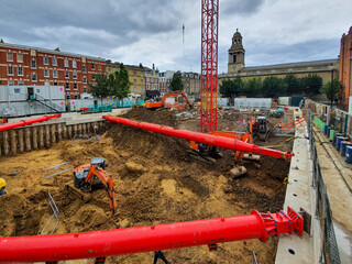 Construction site with large basement excavation, temporary works, capping beams, contiguous pile...