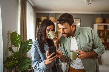 Couple use mobile phone for text message or browse internet at home