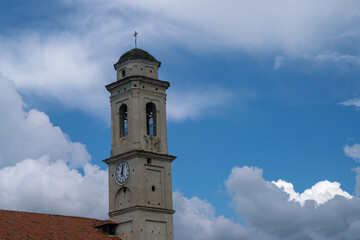 Fototapeta premium Christian church bell tower, sky and clouds background. clock and dome with cross and weathervane on a square base and dome on an octagonal base and stone roofing.