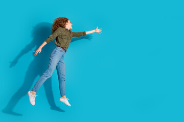 Full body portrait of pretty young woman jump catch empty space wear shirt isolated on turquoise color background