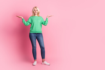 Full length photo of lovely senior lady hold compare empty space dressed stylish green garment isolated on pink color background