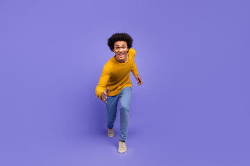 Photo of crazy funny nice man wear trendy yellow clothes run fast isolated on purple color background