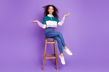 Full size photo of nice young girl sit stool hold empty space vs wear shirt isolated on violet...
