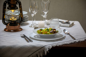 Luxurious table setting with white plates, crystal glasses and fine cutlery. Soup
