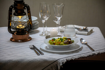 Luxurious table setting with white plates, crystal glasses and fine cutlery. Soup