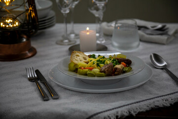 Luxurious table setting with white plates, crystal glasses and fine cutlery. Soup