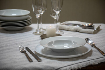 Luxurious table setting with white plates, crystal glasses and fine cutlery