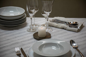 Luxurious table setting with white plates, crystal glasses and fine cutlery