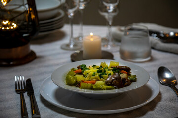 Luxurious table setting with white plates, crystal glasses and fine cutlery. Soup