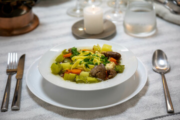 Luxurious table setting with white plates, crystal glasses and fine cutlery. Soup