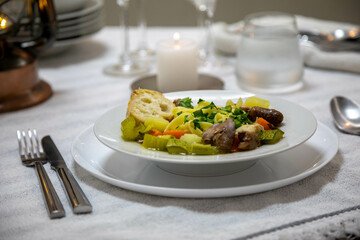 Luxurious table setting with white plates, crystal glasses and fine cutlery. Soup