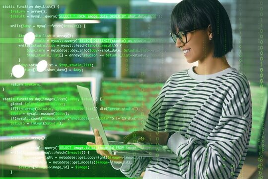 Female programmer working with laptop in office at night