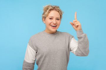Portrait of excited clever smart blonde woman raised her finger showing she has idea about new job...