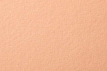 Peach fuzz color paper, closeup. Trendy shade of 2024 year