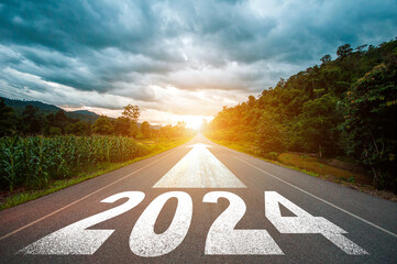 New year 2024 or straight forward concept. Text 2024 written on the road in the middle of asphalt road with at sunset. Concept of planning, goal, challenge, new year resolution..
