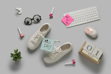 Shoes with tied laces, computer keyboard and calendar on white background. April Fools Day prank