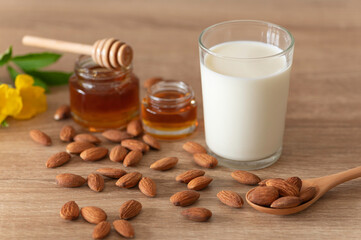 Almonds milk in glass with almonds on wooden table 
