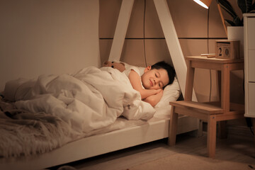 Cute little Asian boy sleeping in bed