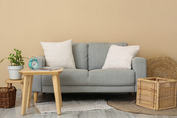Interior of living room with grey sofa, table and baskets