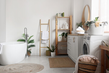 Interior of bathroom with washing machine, laundry baskets and sink