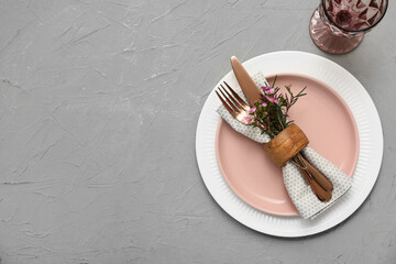 Table setting with beautiful flowers on grey background