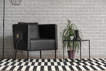 Interior of modern living room with black armchair, table and palm tree