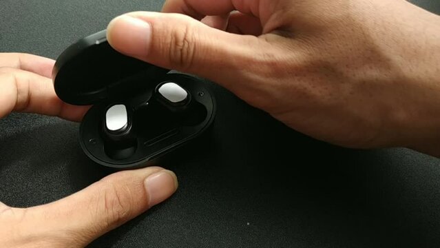 black tws on black table taken by hand