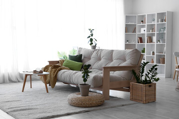 Interior of living room with soft couch and green plants
