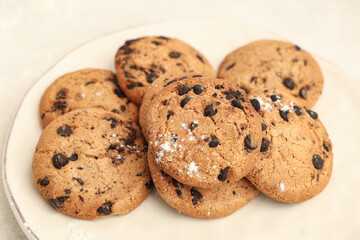 Plate of sweet cookies with chocolate chips on white background, closeup