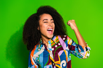 Portrait of pretty young woman raise fist wear shirt isolated on green color background