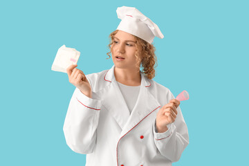Female chef with menstrual pad and cup on blue background