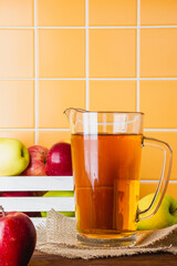 Apple juice in a glass jug on a wooden table