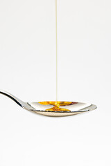 Honey Syrup Drizzling on Spoon, natural organic, Sweet Liquid, White Background