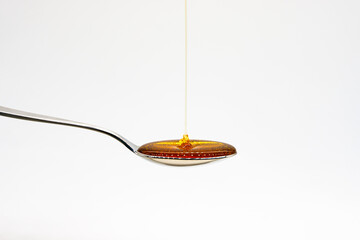 Honey Syrup Drizzling on Spoon, natural organic, Sweet Liquid, White Background