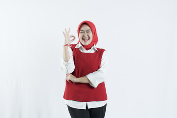 Asian woman in hijab looks happy in Indonesian independence day outfit woman's hand that shows an okay gesture
