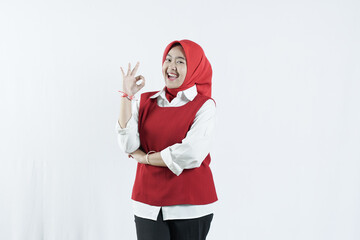 Asian woman in hijab looks happy in Indonesian independence day outfit woman's hand that shows an okay gesture