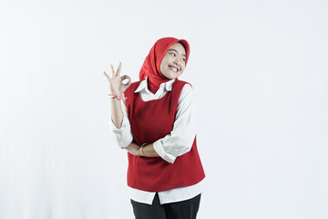Asian woman in hijab looks happy in Indonesian independence day outfit woman's hand that shows an okay gesture