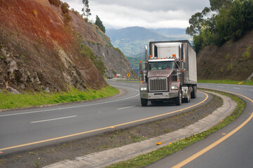 Truck with refrigeration on a curve on a Colombian highway in a rural area