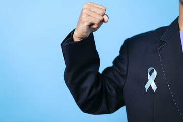 Businessman Clenching Fist With Light Blue Ribbon For Support People Life And Illness. Prostate...