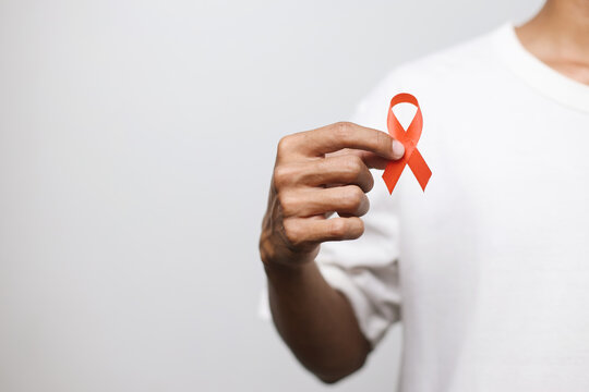 Man Holding Red Ribbon For December World Aids Day Isolated On Whire Background. Healthcare Concept