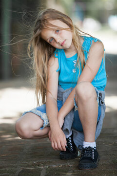 cheerful cute little girl in squatting position.outdoors 