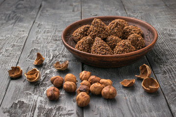 Fresh Hazelnuts and Pine Cones in Wooden Bowl on Rustic Wooden Table