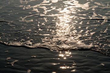 View of the surf on the beach with the sunlight reflection