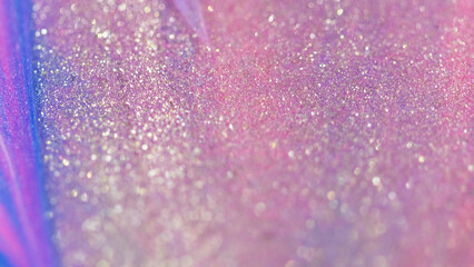 Shiny paint drip. Glitter fluid texture. Defocused pink purple color sparkle particles wet glow ink liquid gloss spill wave abstract art background with bokeh lights.