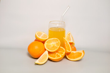 Orange and slices of orange on the background of a glass of orange juice