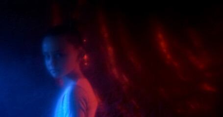 Worried child. Defocused silhouette. Stressed girl walking shocked looking with paranoia in neon dark red light blur plastic texture out of focus.