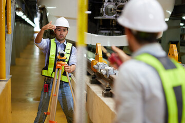 worker or engineer using theodolite surveying optical instrument for measuring at construction...