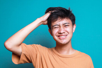 Stressed Young Man Hands Holding Head Isolated on Blue Background